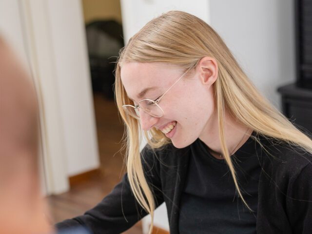 Junge Frau mit langen blonden Haaren und Brille in einer Besprechung. Corinna Marschall ist bei machenlassen.at für Projektmanagement und Social Media zuständig.